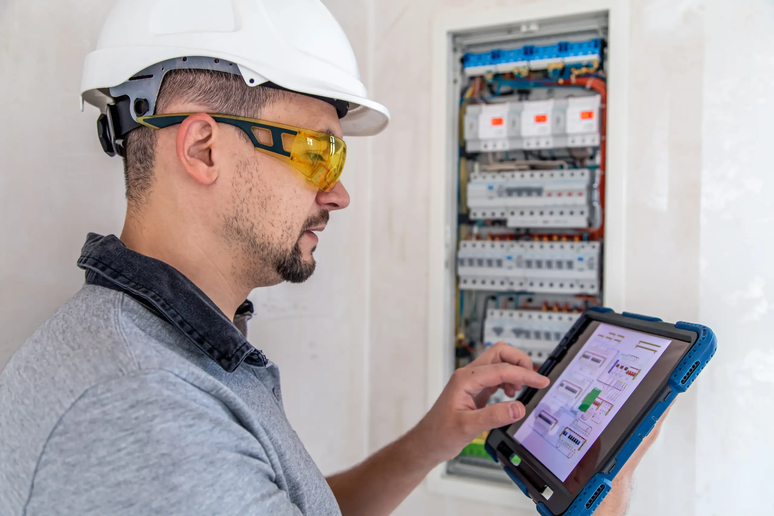 electrical technician looking focused while working switchboard with fuses 1 scaled scaled