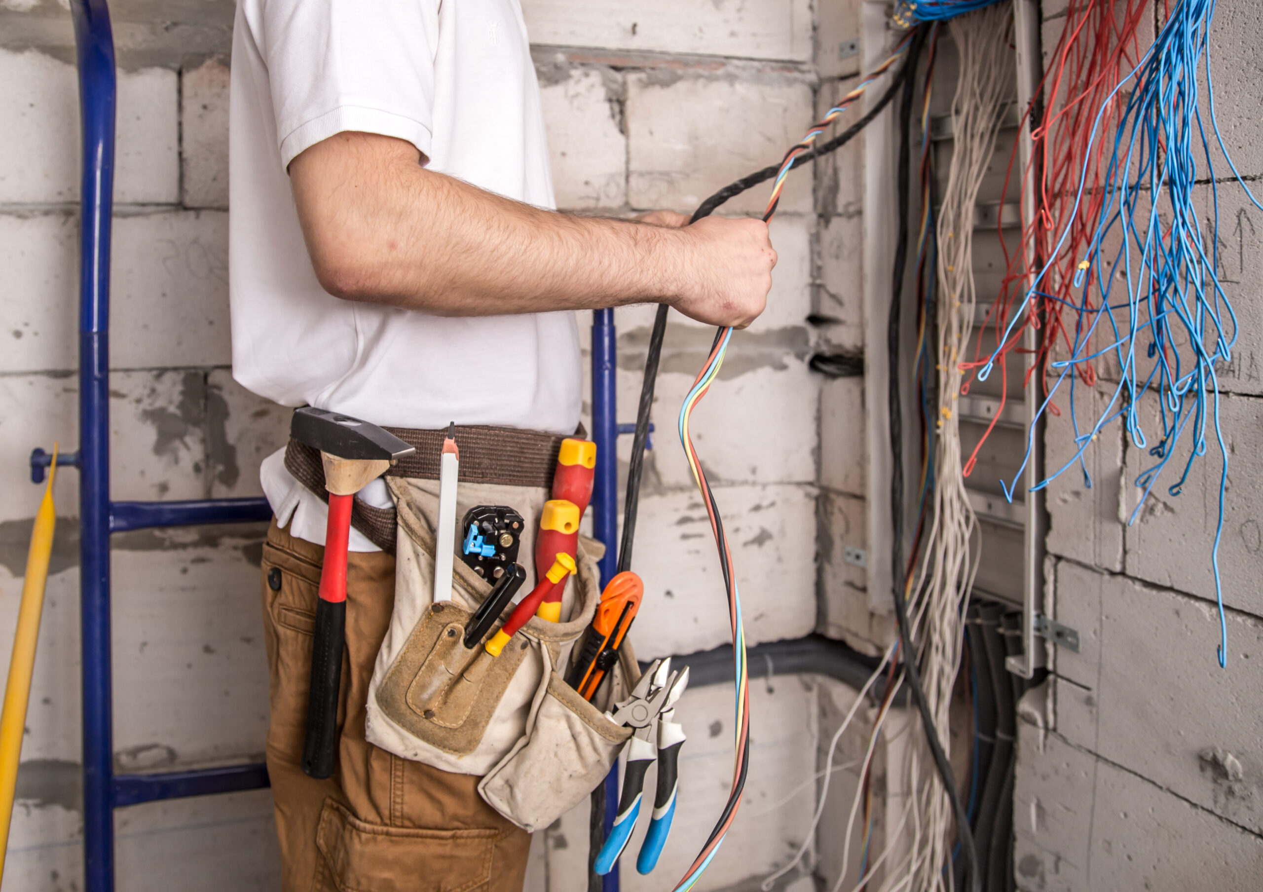 electrician working near board with wires installation connection electrics scaled